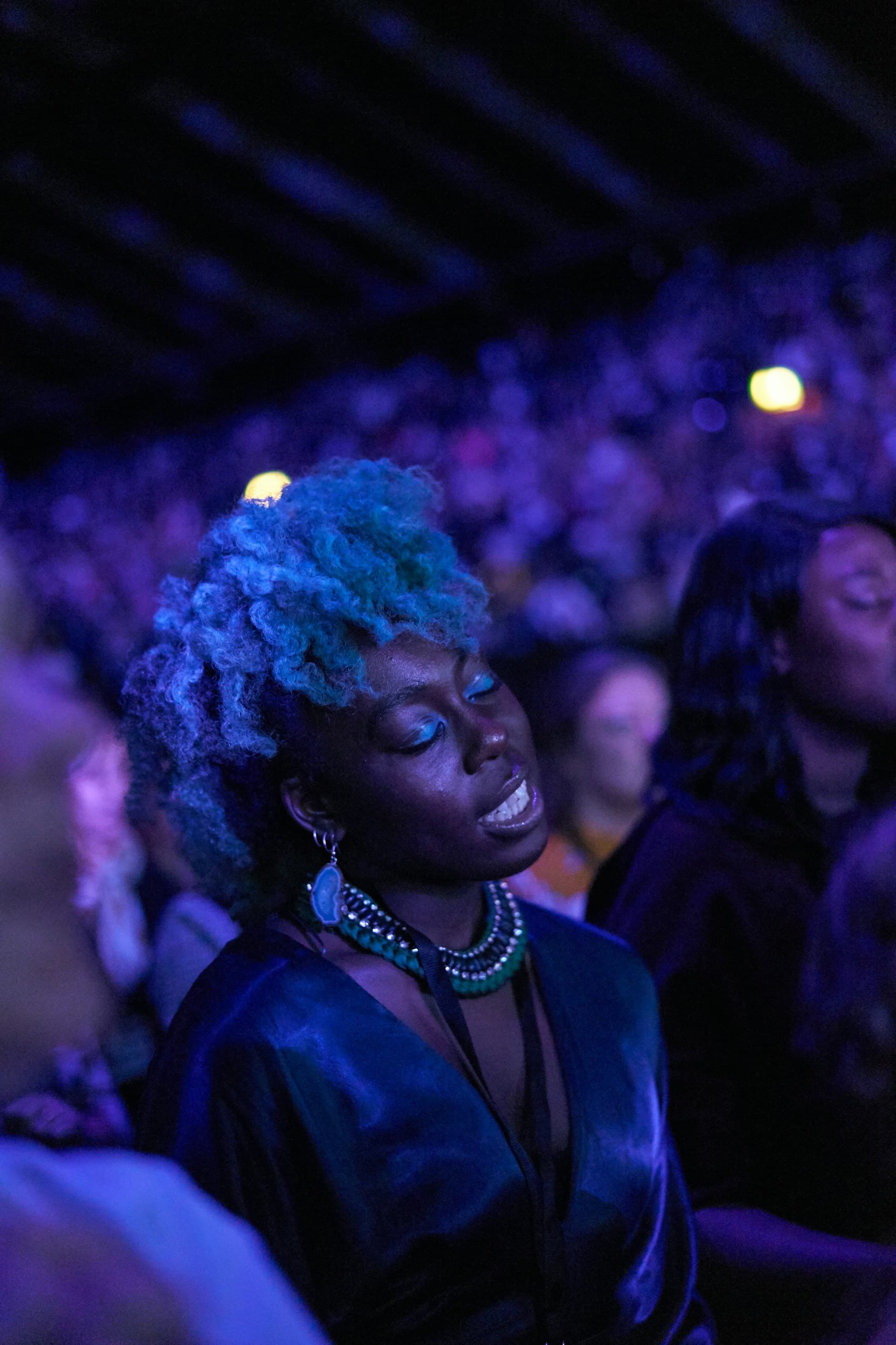 Woman enjoying a concert with purple lighting